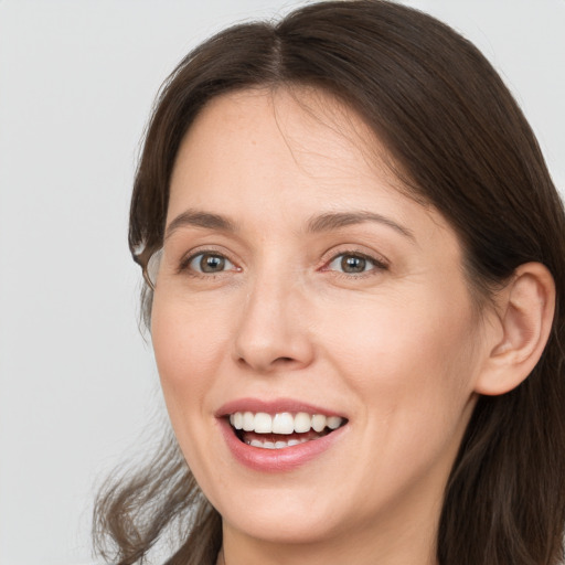 Joyful white young-adult female with long  brown hair and grey eyes