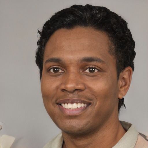 Joyful black young-adult male with short  brown hair and brown eyes