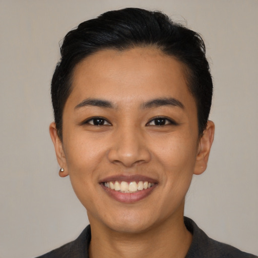 Joyful latino young-adult female with short  black hair and brown eyes