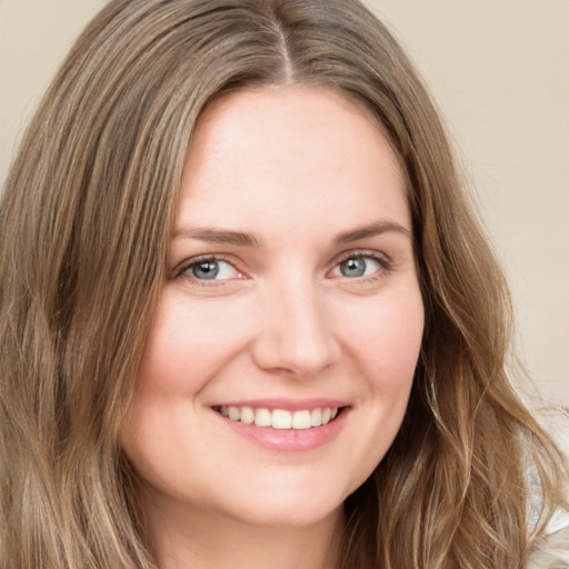 Joyful white young-adult female with long  brown hair and green eyes