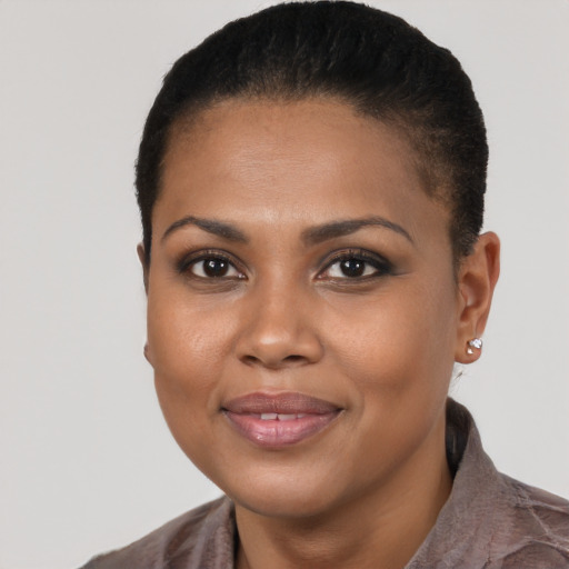 Joyful black young-adult female with short  black hair and brown eyes