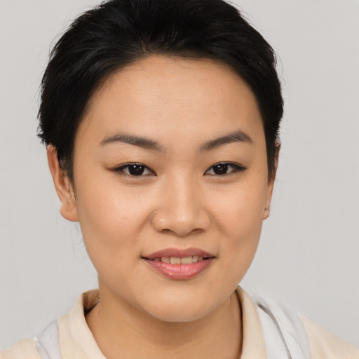 Joyful asian young-adult female with short  brown hair and brown eyes