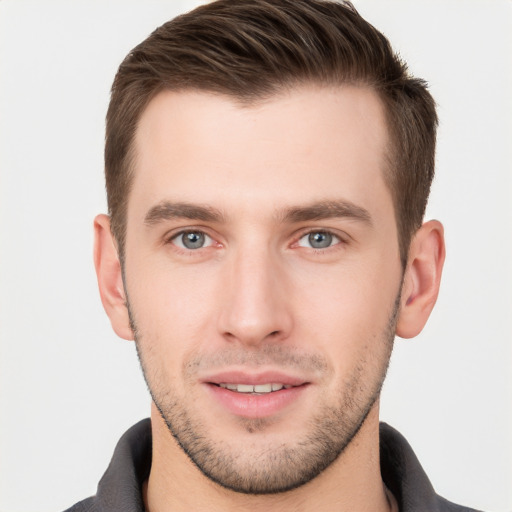 Joyful white young-adult male with short  brown hair and grey eyes