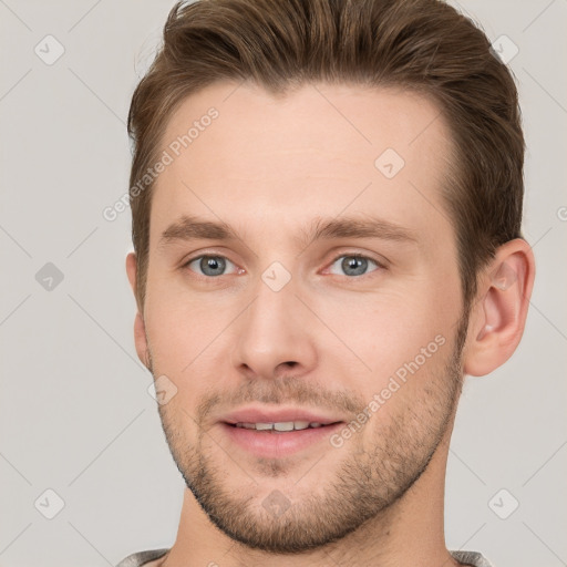 Joyful white young-adult male with short  brown hair and grey eyes