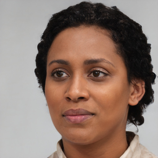 Joyful black young-adult female with short  black hair and brown eyes