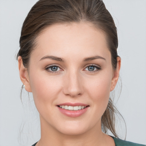 Joyful white young-adult female with medium  brown hair and grey eyes