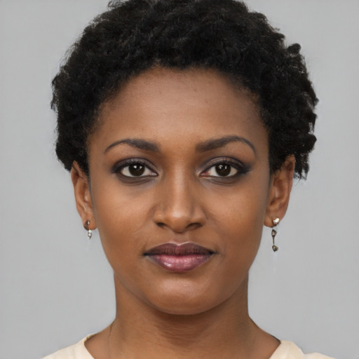 Joyful black young-adult female with short  black hair and brown eyes