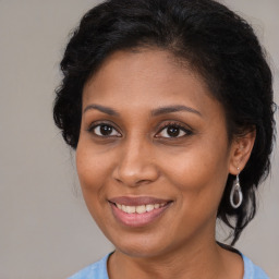 Joyful black young-adult female with medium  brown hair and brown eyes