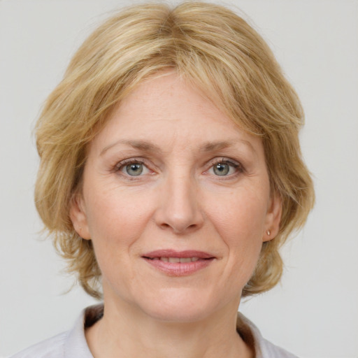 Joyful white adult female with medium  brown hair and blue eyes