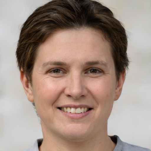 Joyful white adult female with short  brown hair and grey eyes