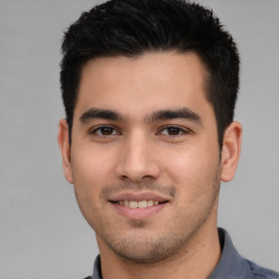 Joyful white young-adult male with short  black hair and brown eyes