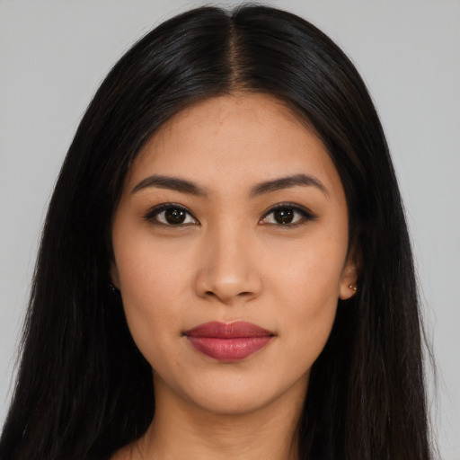 Joyful latino young-adult female with long  black hair and brown eyes