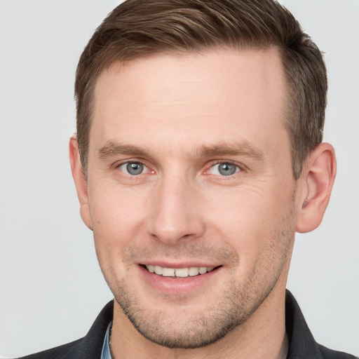 Joyful white young-adult male with short  brown hair and grey eyes