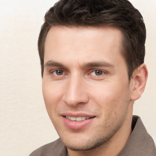 Joyful white young-adult male with short  brown hair and brown eyes