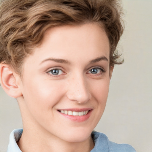 Joyful white young-adult female with short  brown hair and blue eyes