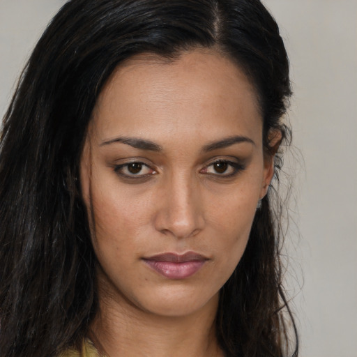 Joyful black young-adult female with long  brown hair and brown eyes