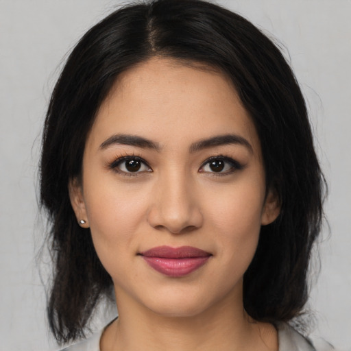 Joyful latino young-adult female with medium  black hair and brown eyes