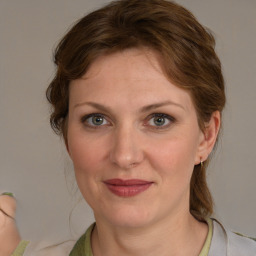 Joyful white young-adult female with medium  brown hair and blue eyes