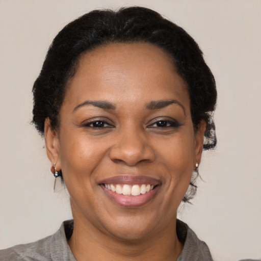 Joyful black adult female with medium  black hair and brown eyes