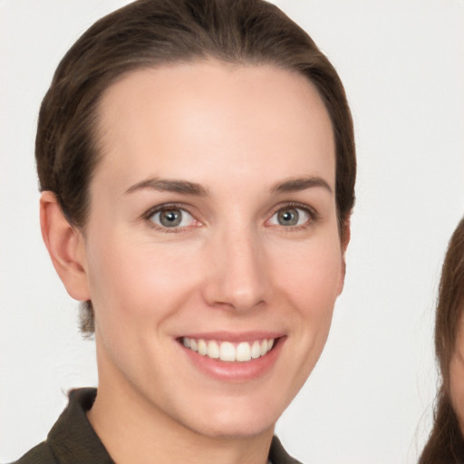 Joyful white young-adult female with medium  brown hair and grey eyes