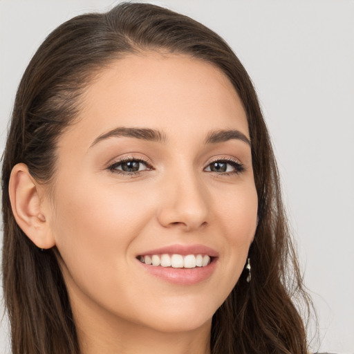 Joyful white young-adult female with long  brown hair and brown eyes