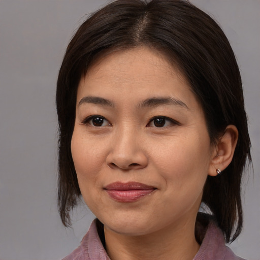 Joyful asian adult female with medium  brown hair and brown eyes
