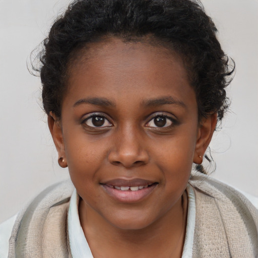 Joyful black child female with short  brown hair and brown eyes
