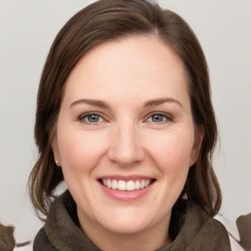 Joyful white young-adult female with medium  brown hair and grey eyes