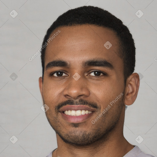 Joyful black young-adult male with short  black hair and brown eyes