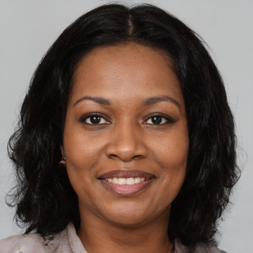 Joyful black young-adult female with medium  black hair and brown eyes