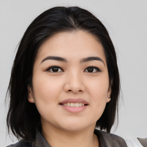 Joyful asian young-adult female with medium  black hair and brown eyes