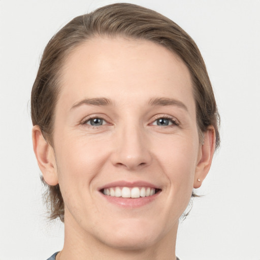 Joyful white young-adult female with medium  brown hair and grey eyes