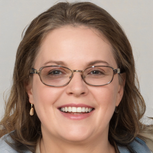 Joyful white adult female with medium  brown hair and blue eyes