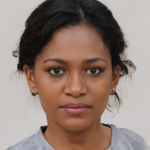 Joyful black young-adult female with short  brown hair and brown eyes