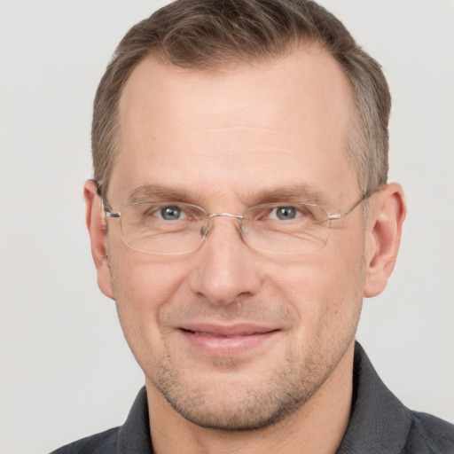 Joyful white adult male with short  brown hair and grey eyes