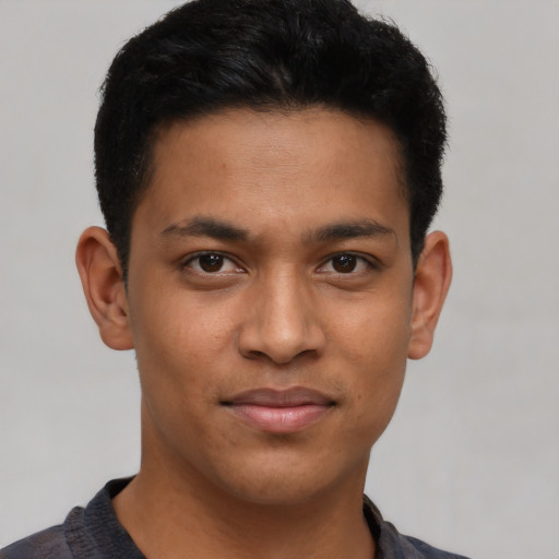 Joyful latino young-adult male with short  brown hair and brown eyes