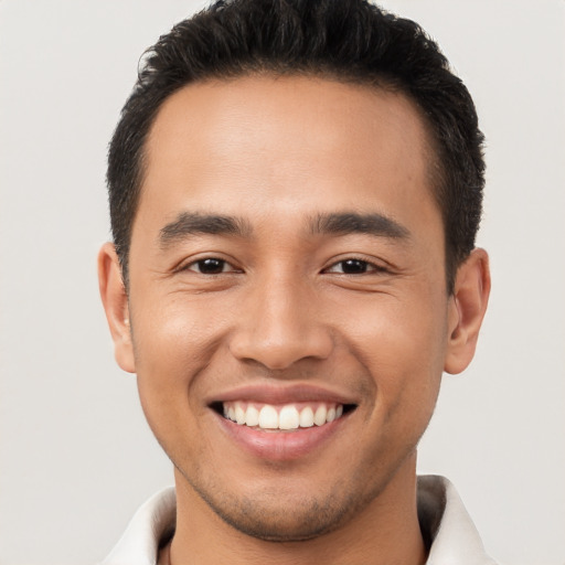 Joyful latino young-adult male with short  brown hair and brown eyes