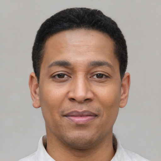 Joyful latino young-adult male with short  brown hair and brown eyes