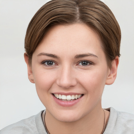 Joyful white young-adult female with short  brown hair and grey eyes