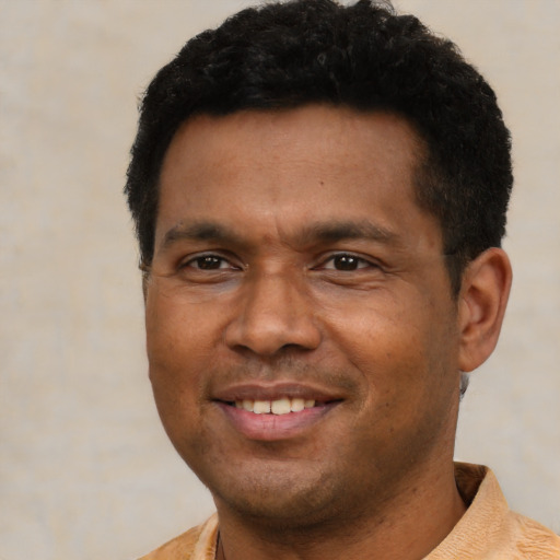 Joyful latino adult male with short  black hair and brown eyes