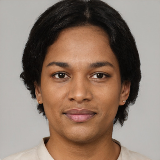 Joyful black young-adult female with short  black hair and brown eyes