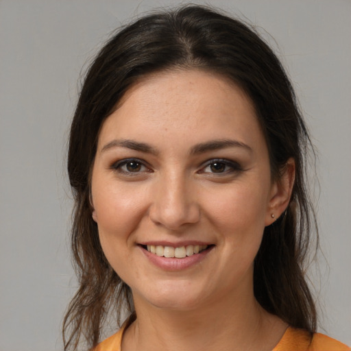 Joyful white young-adult female with medium  brown hair and brown eyes