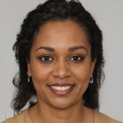 Joyful black young-adult female with long  brown hair and brown eyes