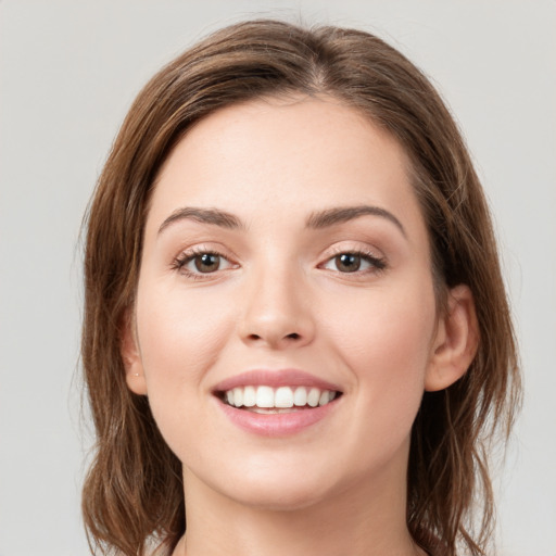 Joyful white young-adult female with medium  brown hair and green eyes