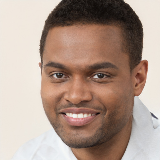 Joyful black young-adult male with short  brown hair and brown eyes