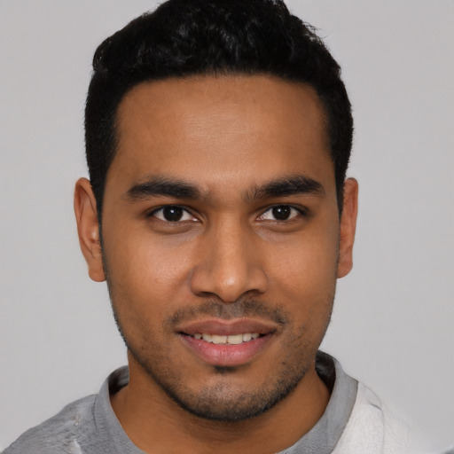 Joyful latino young-adult male with short  black hair and brown eyes
