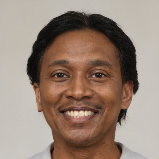 Joyful black adult male with short  black hair and brown eyes