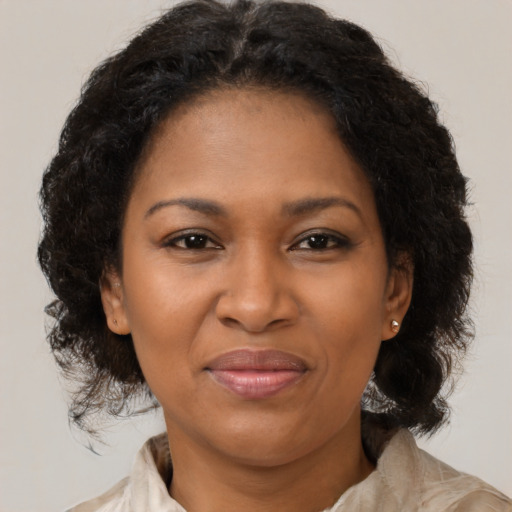 Joyful black adult female with medium  brown hair and brown eyes