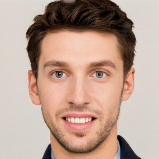 Joyful white young-adult male with short  brown hair and grey eyes