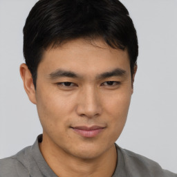 Joyful asian young-adult male with short  brown hair and brown eyes